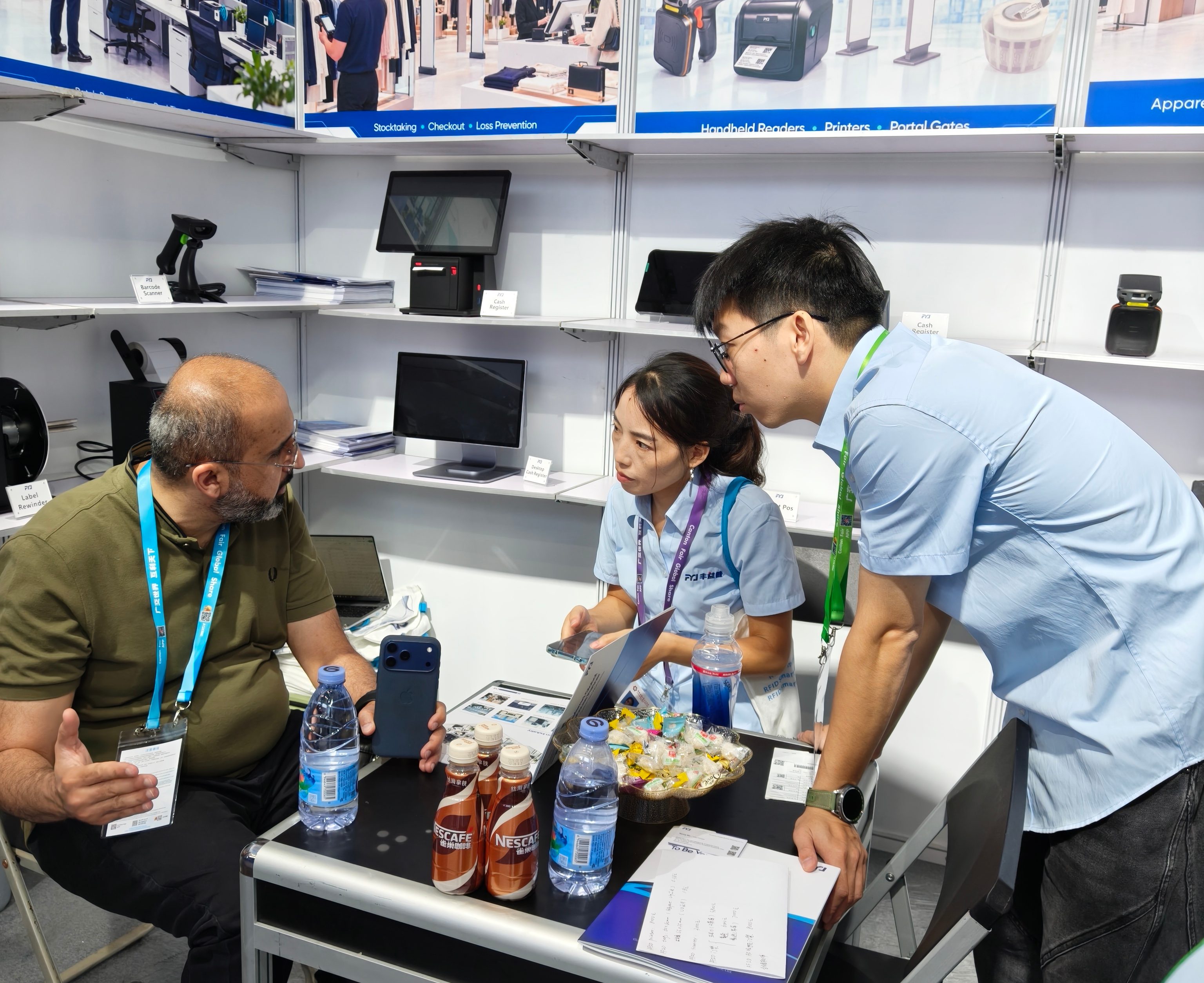 Visitors discussing RFID warehouse, retail and system integration requirements with the FYJ team